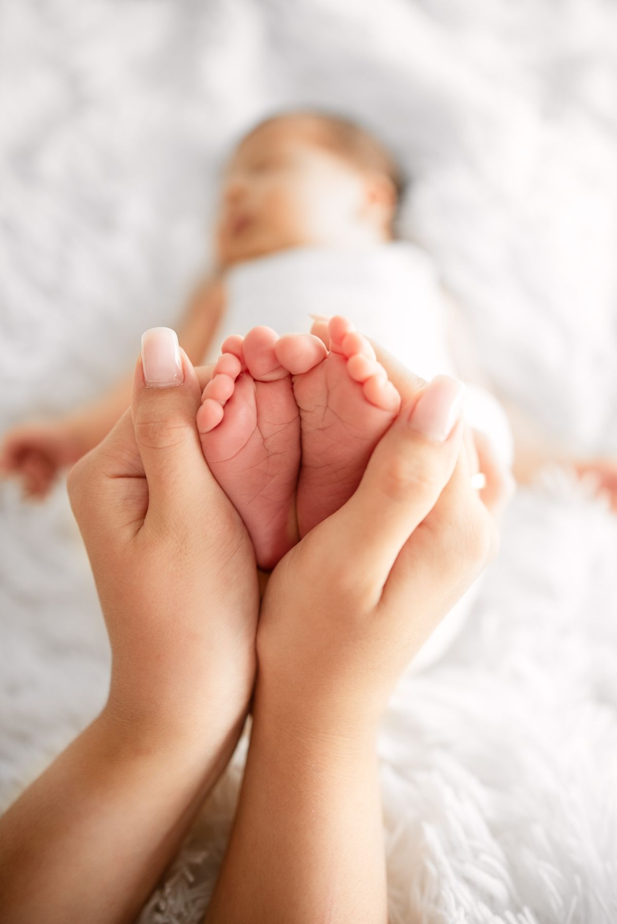 Babyfüße behutsam in den Händen eines Elternteils