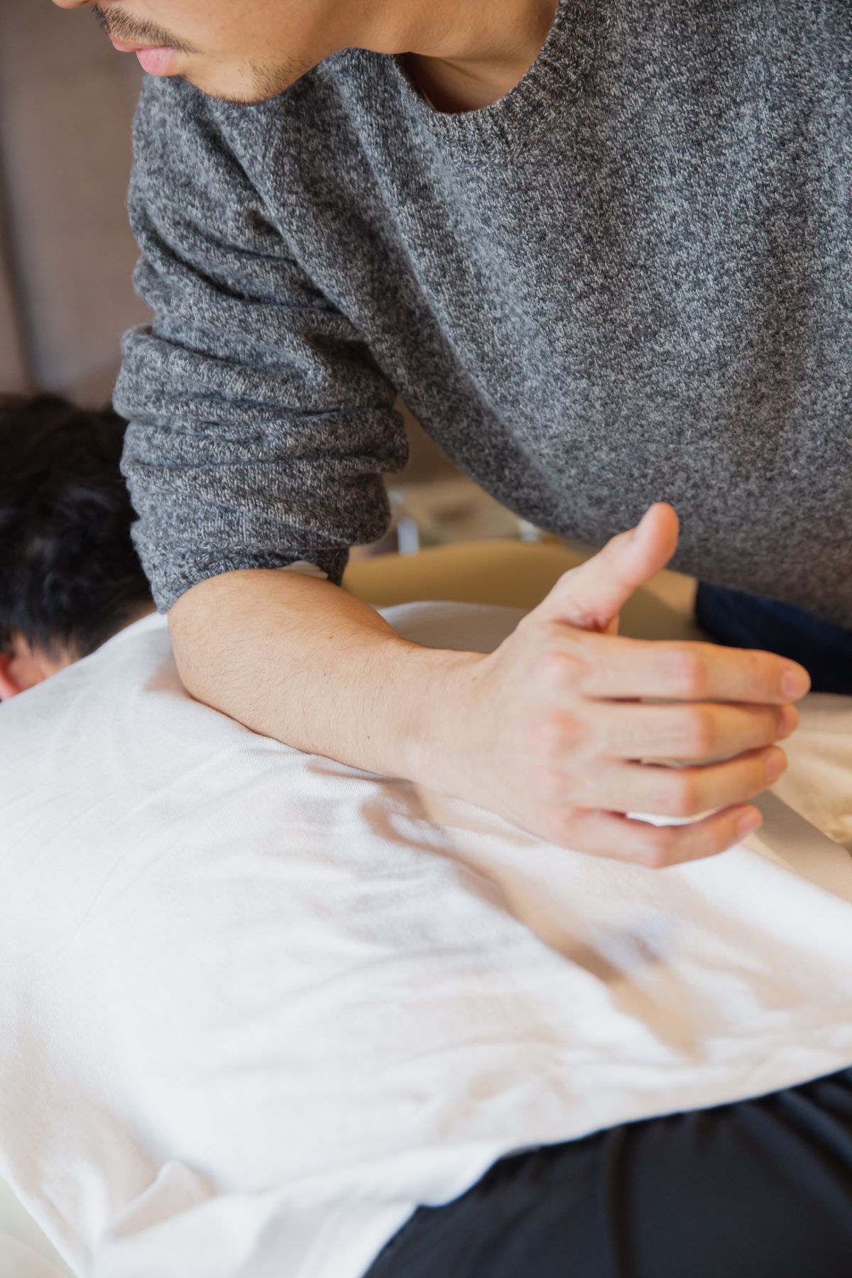 Behandelnde Hände bei einer osteopathischen Anwendung